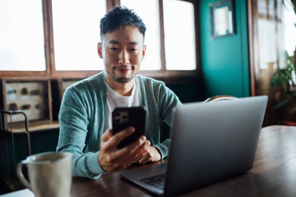 asian man phone laptop