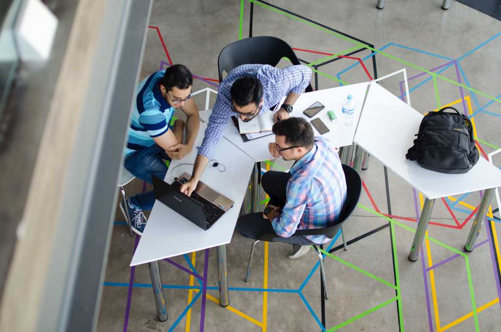 Colleagues looking at computer screen shot from above