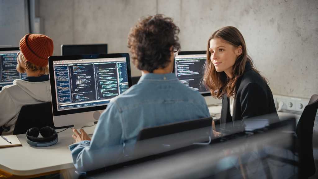 Smart Young Students Studying in University with Diverse Multiethnic Classmates. Scholars Collaborate in College Room on Computer Science Project, Writing Software Code in Successful Teamwork.