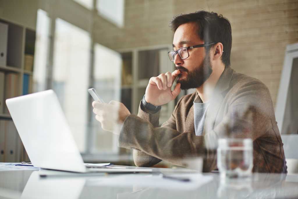 Modern office worker writing sms